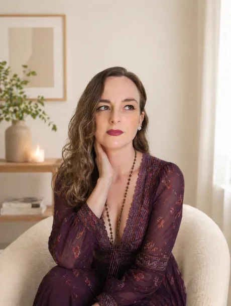 Cintia Blank, sentada, com vestido vinho